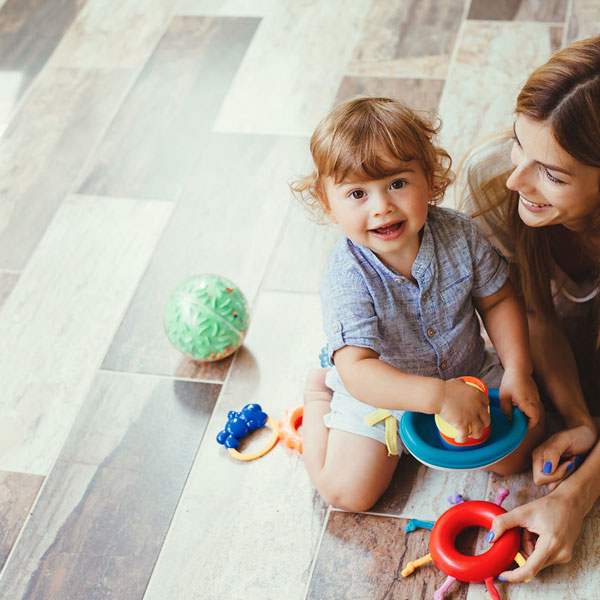 mother and child playing on tile floor